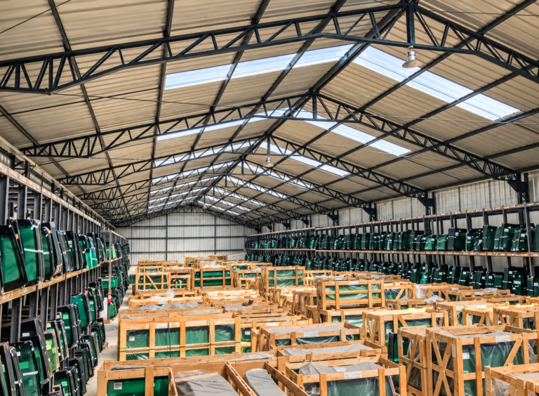 Interior de la bodega de Cristal Autos con parabrisas en estanterías y embalajes de madera, imagen proporcionada por la empresa